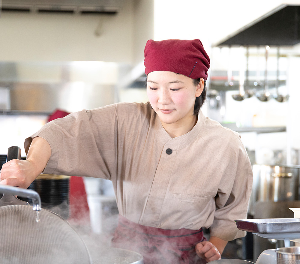 蕎麦を茹でようとしている店員さんの画像